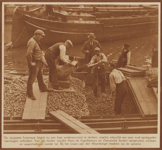 873724 Afbeelding van het lossen van aardappelen uit een vrachtschip op de Stadsbuitengracht, afgemeerd aan de ...